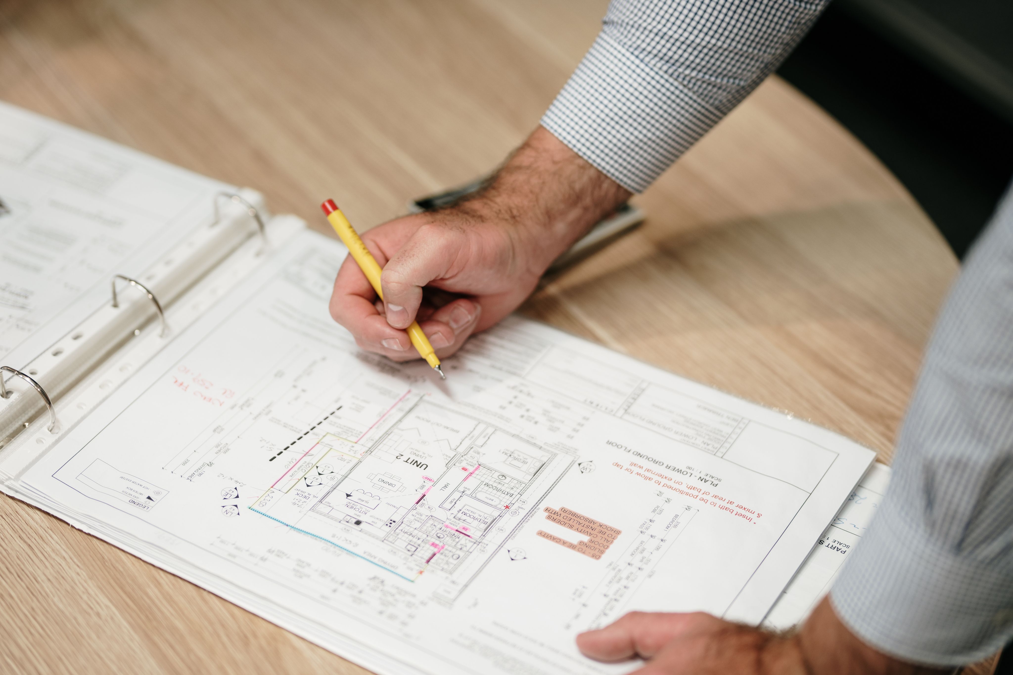 Architect making changes to a hotel blueprint with a pencil