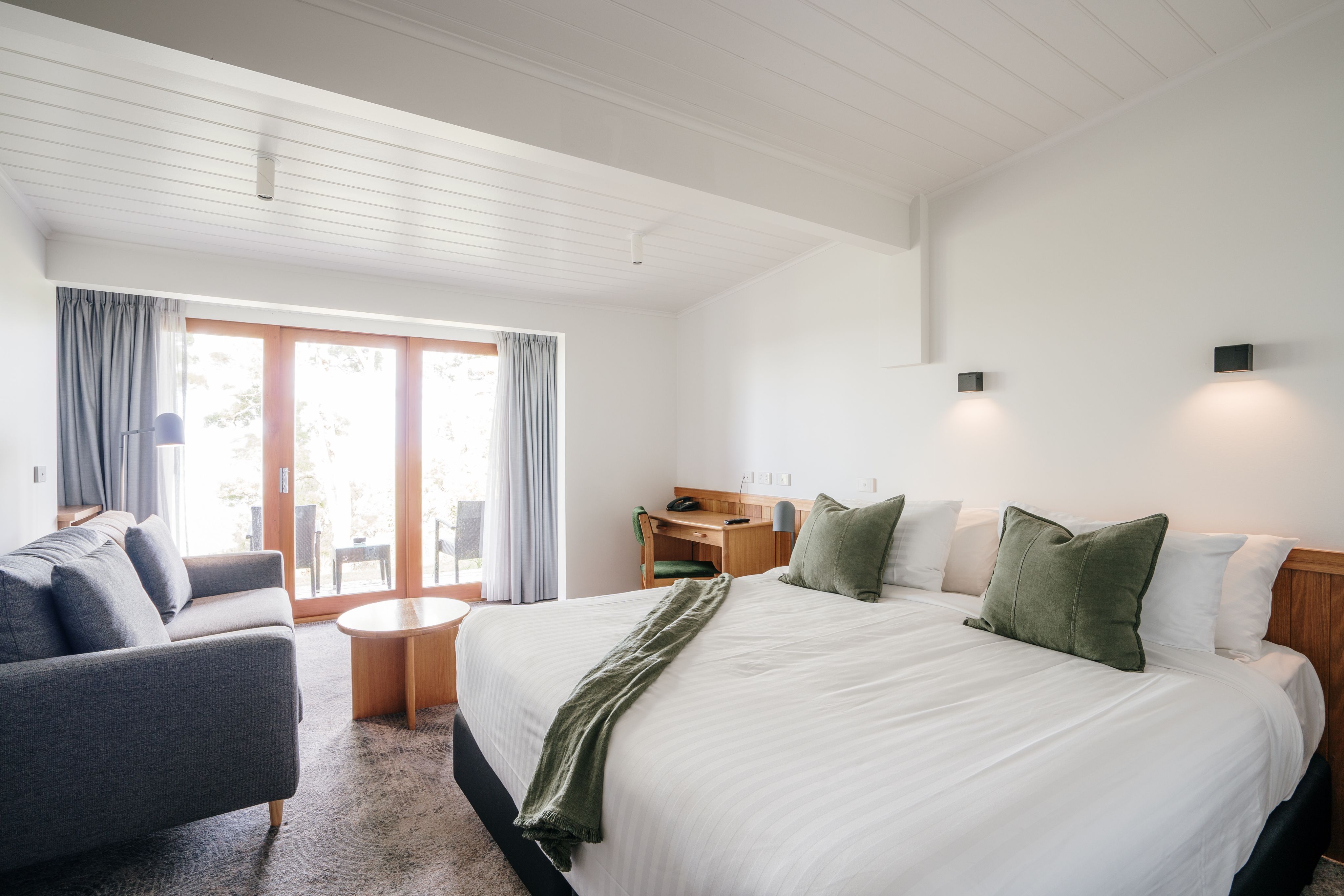 Hotel room with warm timber detailing and soft furnishings